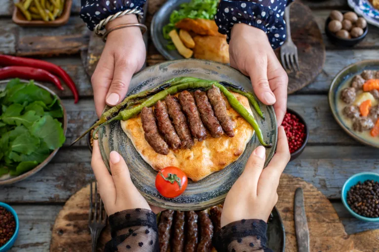 Burgers with grilled green pepper and tomato in the serving plate.